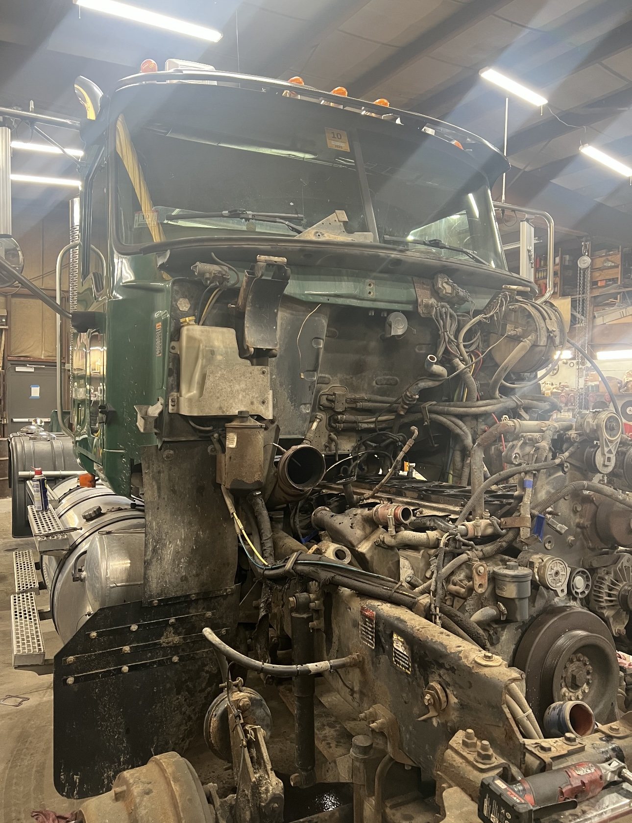 Truck with engine and front-end components exposed for repair